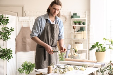 Male florist pruning stem at workplace