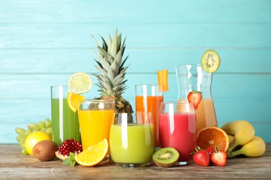 Glassware with different juices and fresh fruits on table