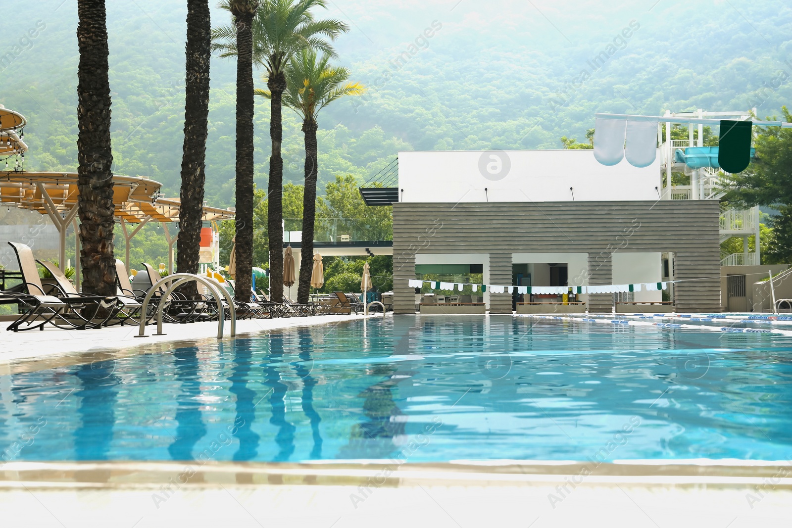 Photo of Swimming pool and sunbeds at luxury resort