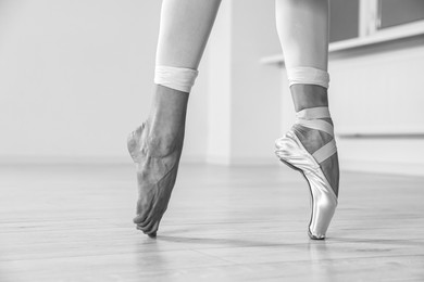 Image of Ballerina in pointe shoe dancing indoors, closeup. Black and white effect