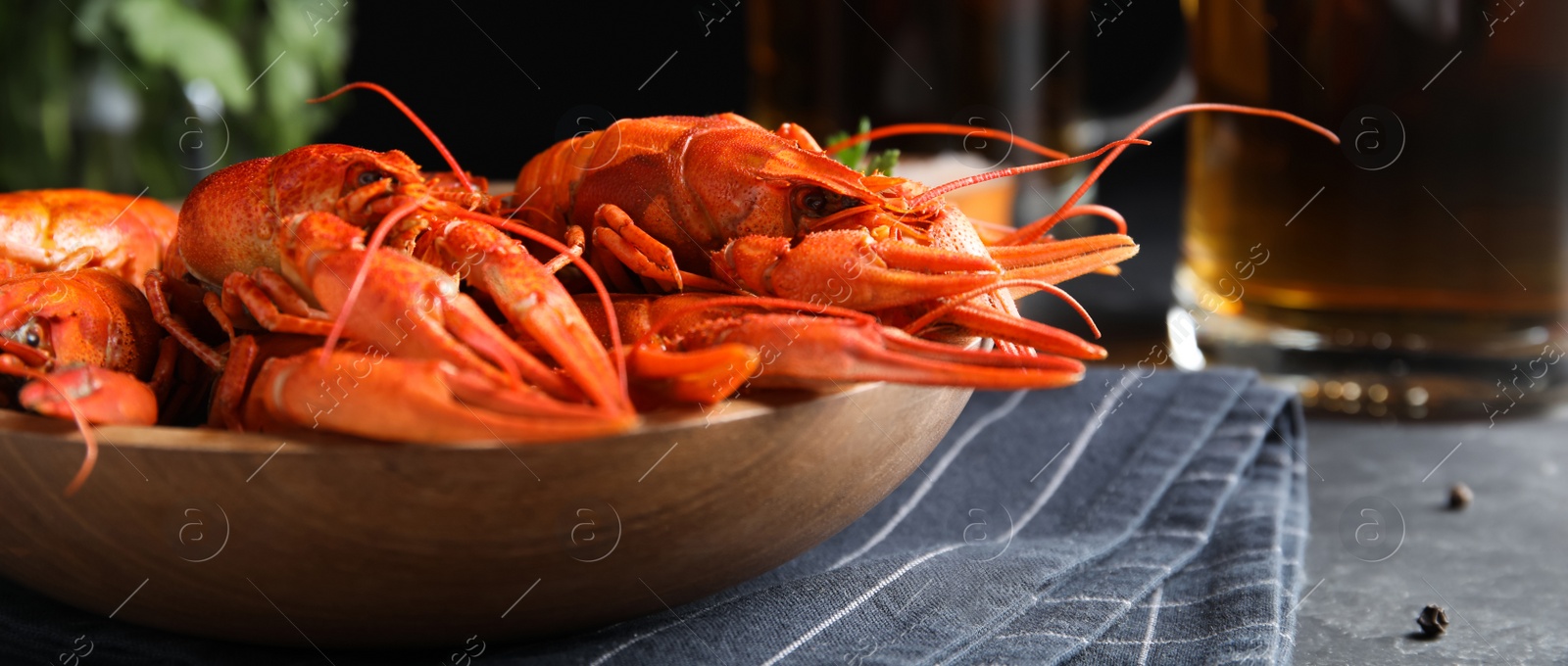 Image of Delicious red boiled crayfishes on table, closeup. Banner design