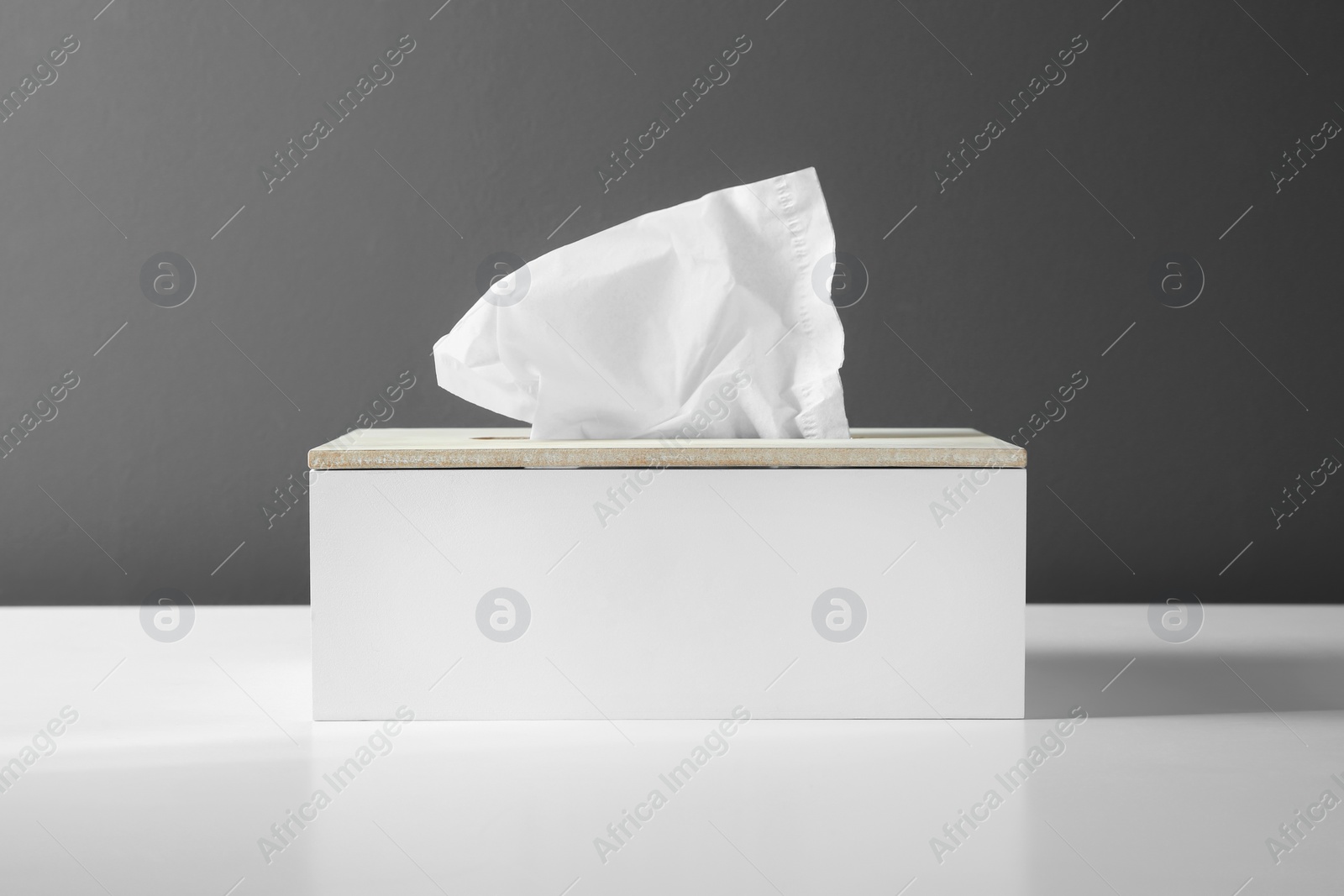 Photo of Holder with paper tissues on white table