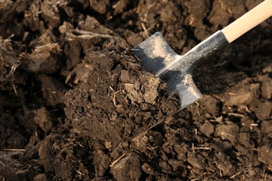 Photo of Digging soil with shovel outdoors. Gardening tool