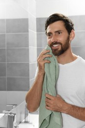 Photo of Handsome man drying his beard in bathroom