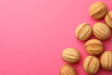 Photo of Homemade walnut shaped cookies with condensed milk on pink background, flat lay. Space for text