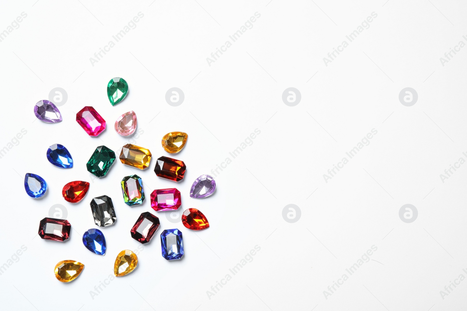 Photo of Different beautiful gemstones on white background, top view