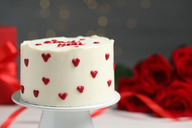 Photo of Bento cake and roses on white table, closeup. St. Valentine's day surprise