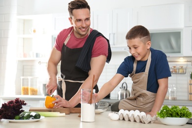 Photo of Dad and son cooking together in kitchen