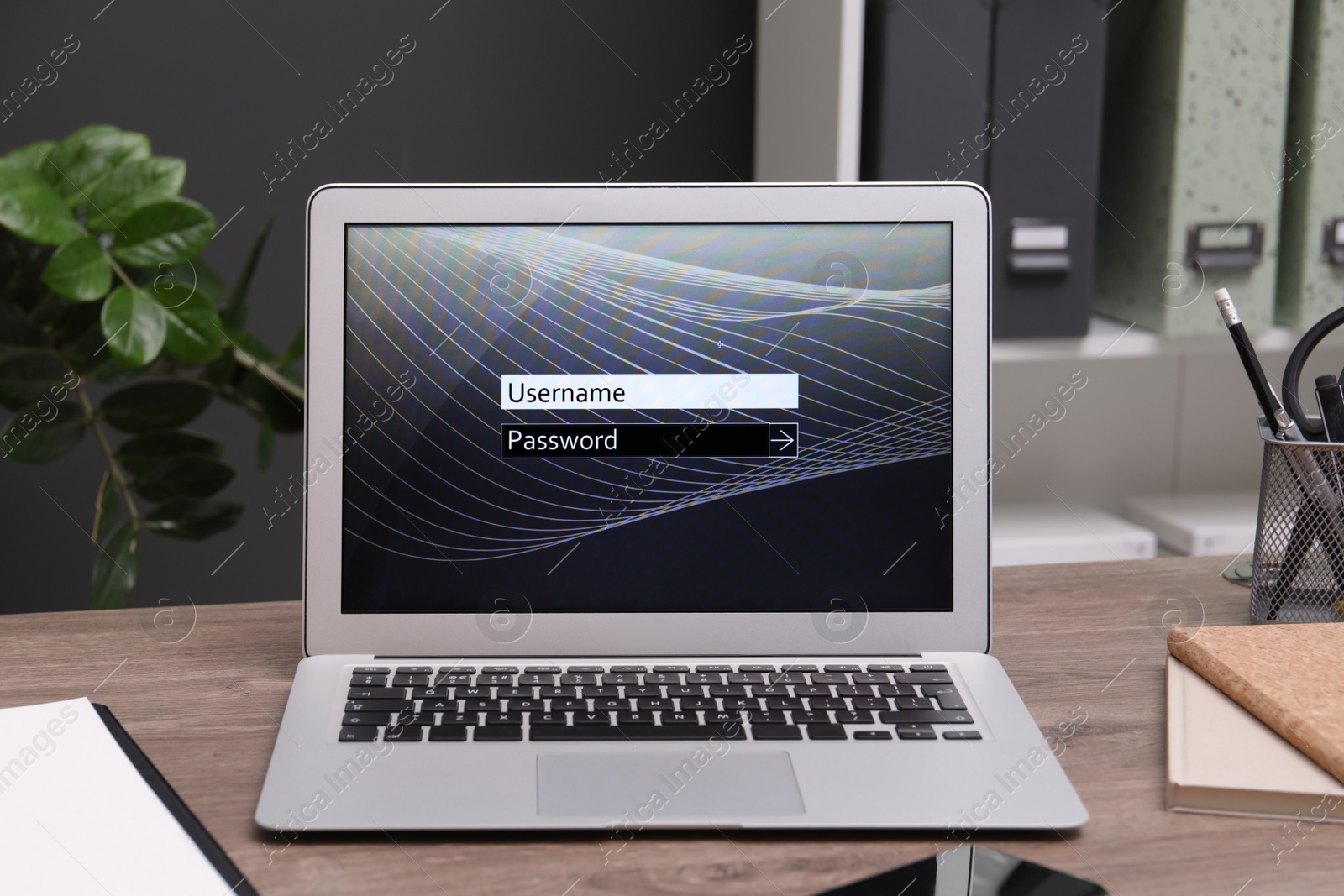 Photo of Modern laptop with blocked screen on wooden table in office