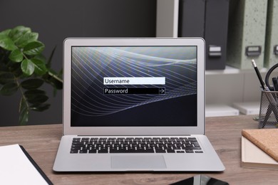 Photo of Modern laptop with blocked screen on wooden table in office