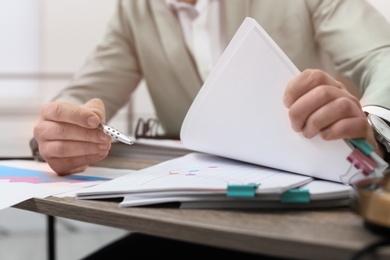 Businessman working with documents at office table, closeup