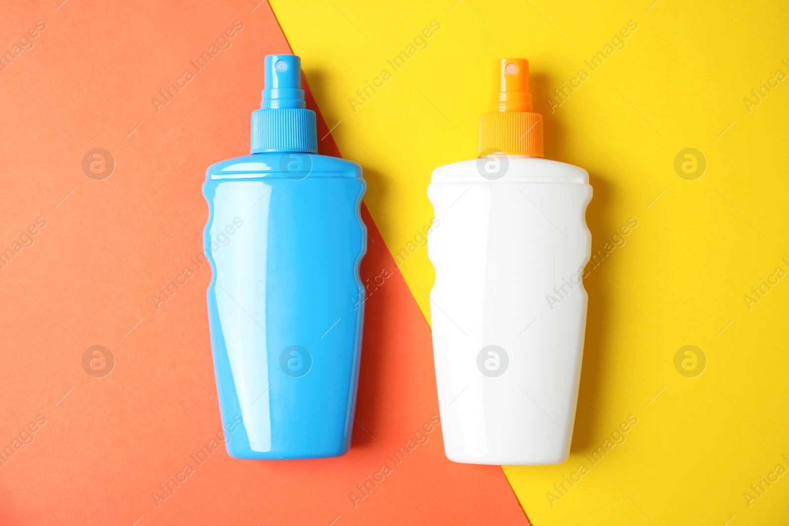 Photo of Bottles with sun protection body cream on color background, top view