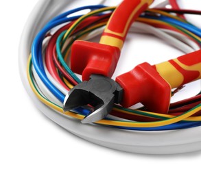 Photo of Colorful cables and cutting pliers on white background, closeup with space for text. Electrician's tool