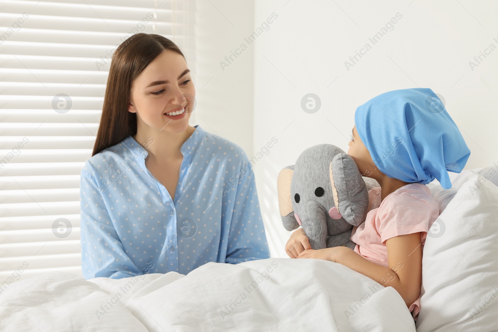 Photo of Childhood cancer. Mother and daughter with toy elephant in hospital