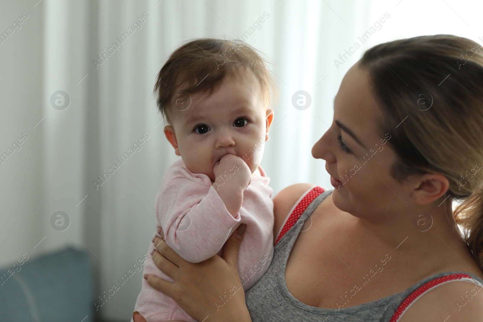 Photo of Young woman with her cute baby at home