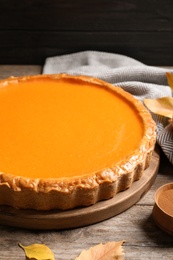 Photo of Fresh delicious homemade pumpkin pie served on wooden table