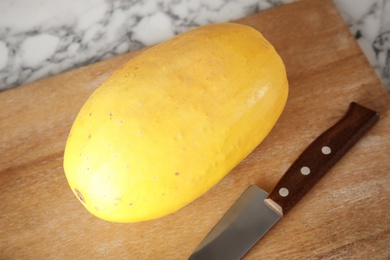 Photo of Cutting board with ripe spaghetti squash on table