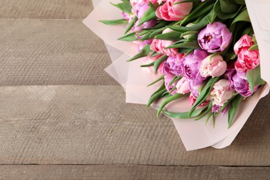 Bouquet of beautiful tulips on wooden table, closeup. Space for text
