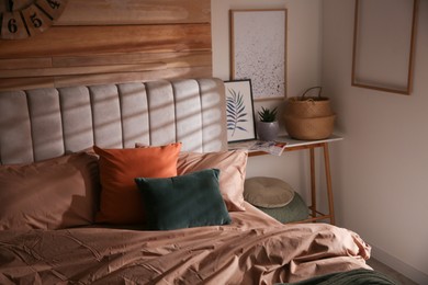 Photo of Bed with stylish linen and soft pillows in room