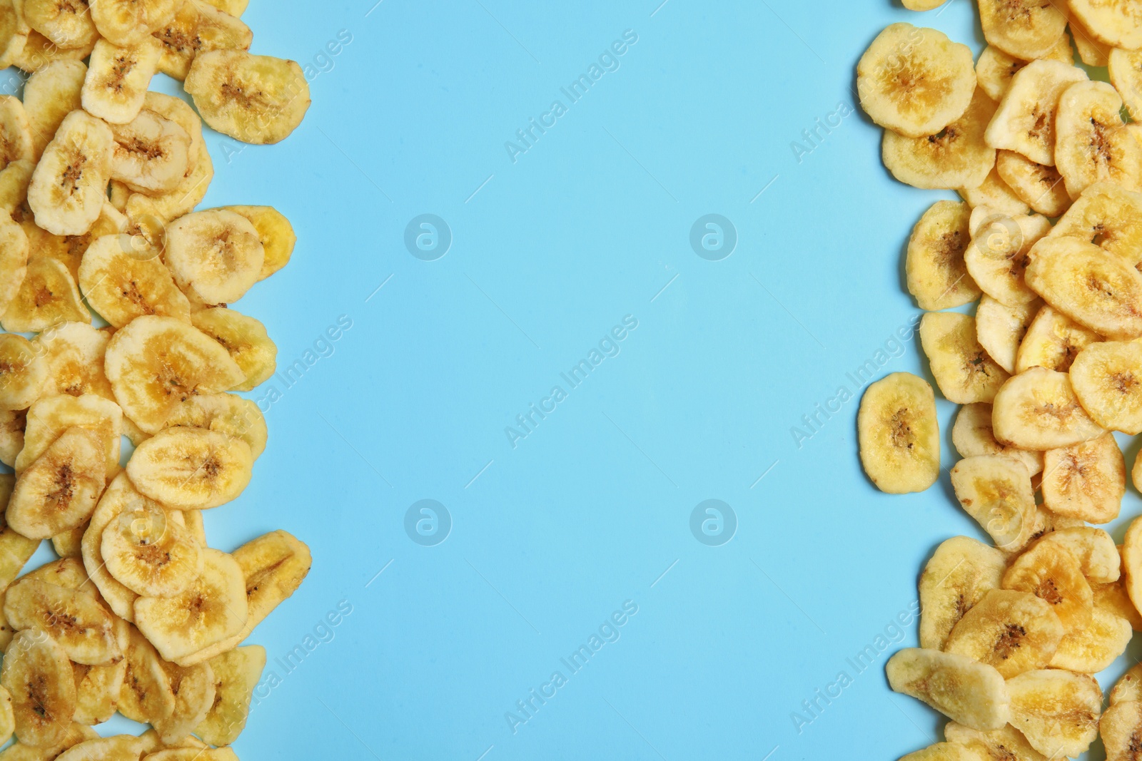 Photo of Frame made of sweet banana slices on color  background, top view with space for text. Dried fruit as healthy snack