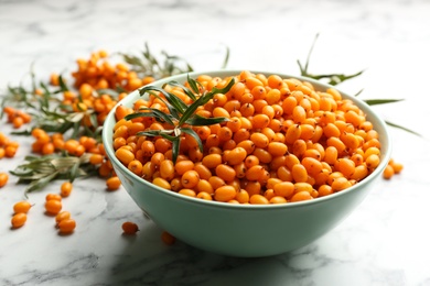 Ripe sea buckthorn berries on white marble table, closeup