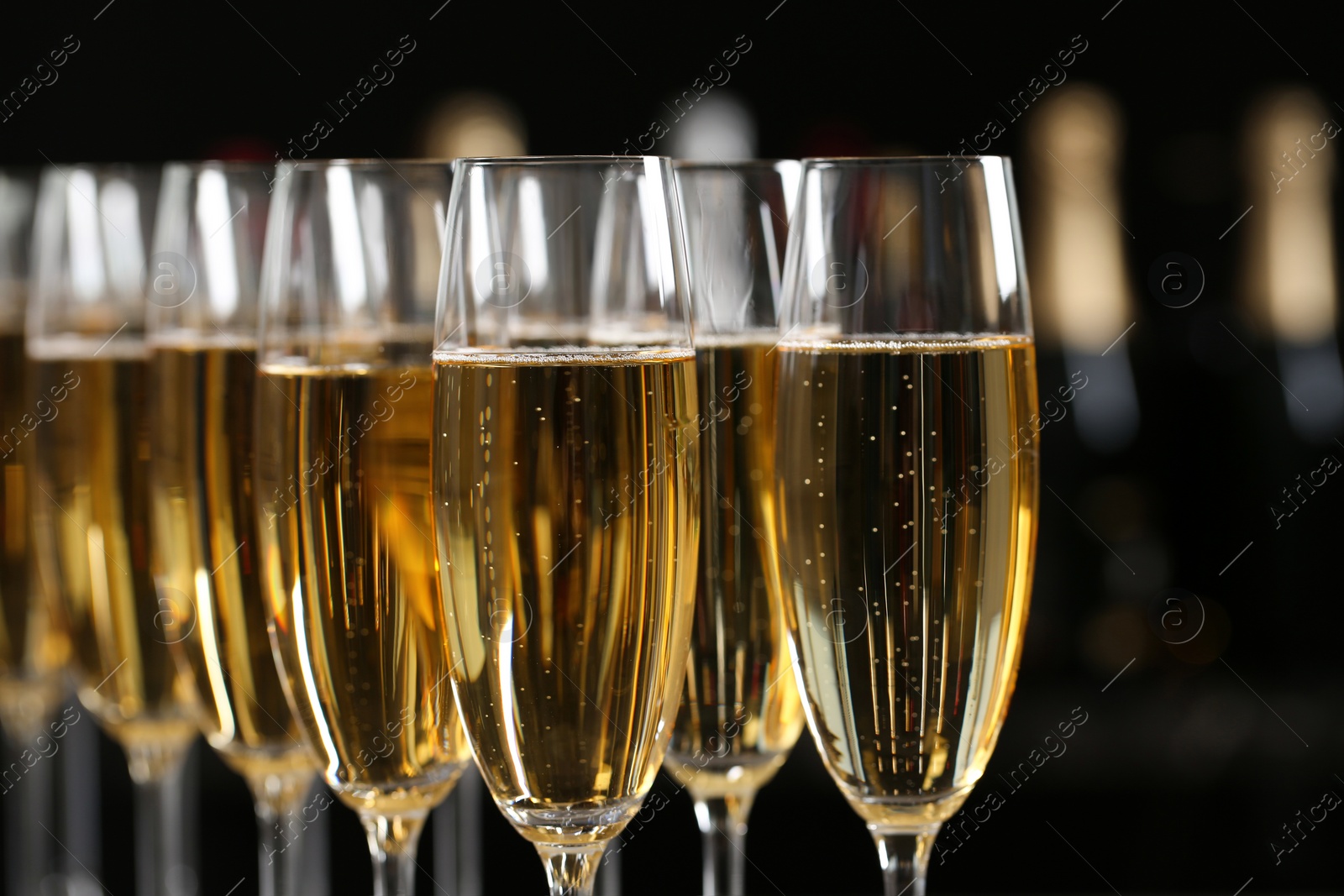 Photo of Many glasses of champagne on blurred background, closeup