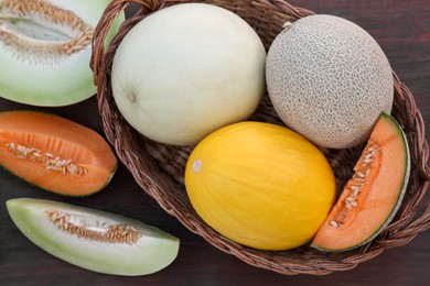Photo of Tasty ripe melons on wooden table, flat lay