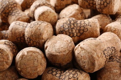 Photo of Many corks of wine bottles with grape images as background, closeup