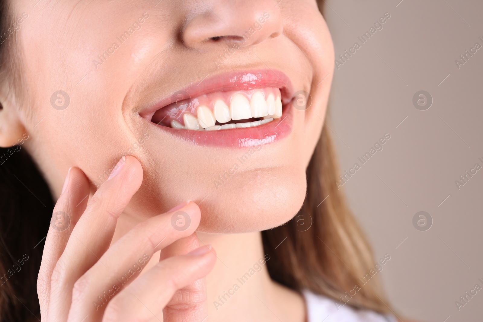 Photo of Young woman with healthy teeth smiling on color background, closeup