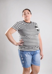 Fat woman on grey background. Weight loss