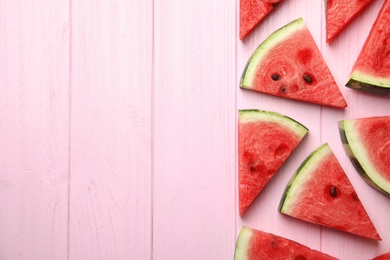 Photo of Slices of ripe watermelon on pink wooden table, flat lay. Space for text