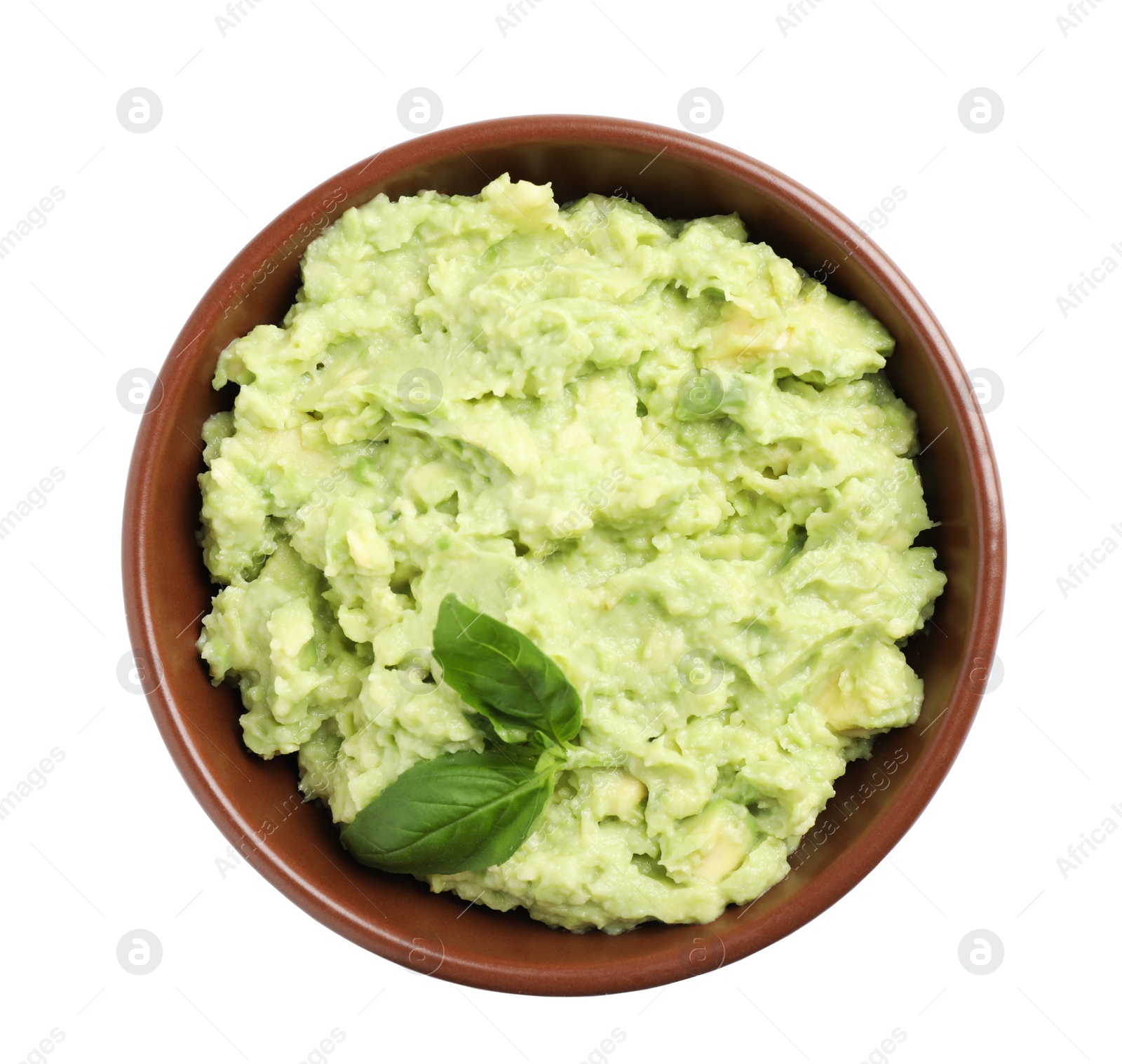 Photo of Bowl of tasty avocado sauce with basil on white background, top view