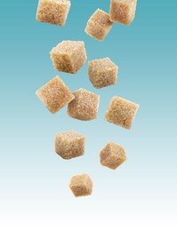 Image of Brown cane sugar cubes falling on light blue gradient background