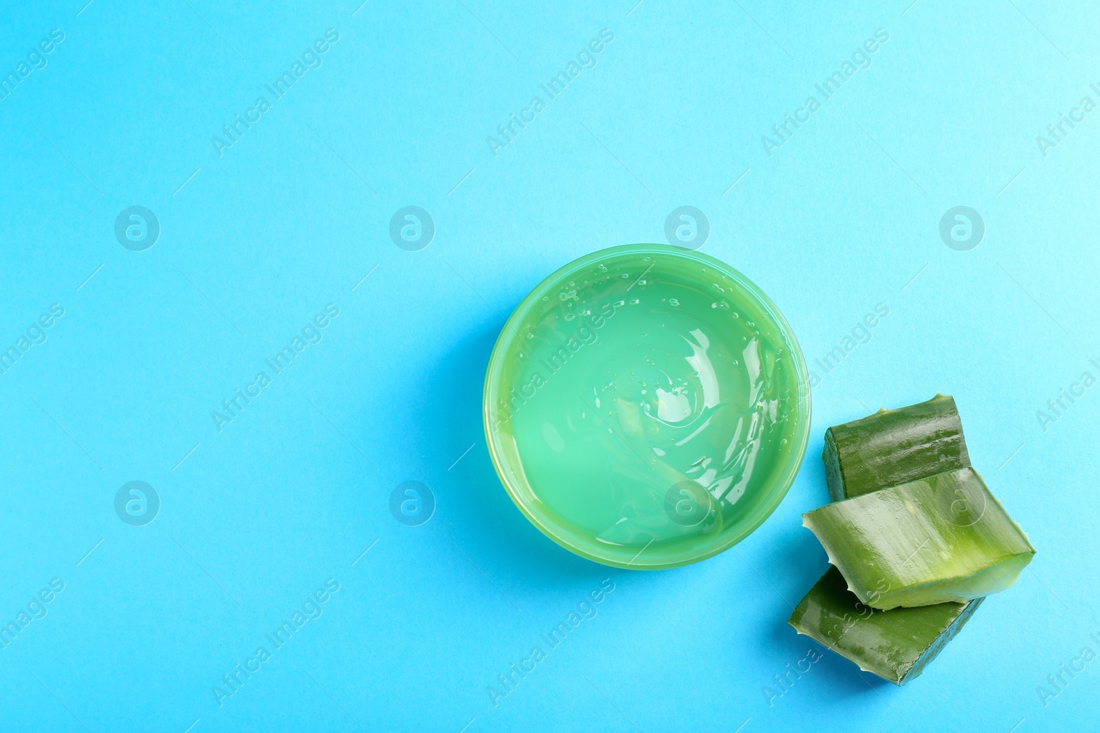 Photo of Aloe gel and plant on light blue background, flat lay. Space for text