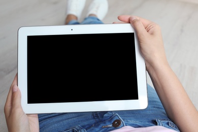 Photo of Woman holding tablet with blank screen indoors. Mockup for design