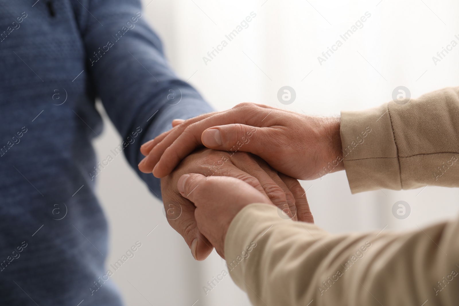 Photo of Trust and deal. Men joining hands on blurred background, closeup