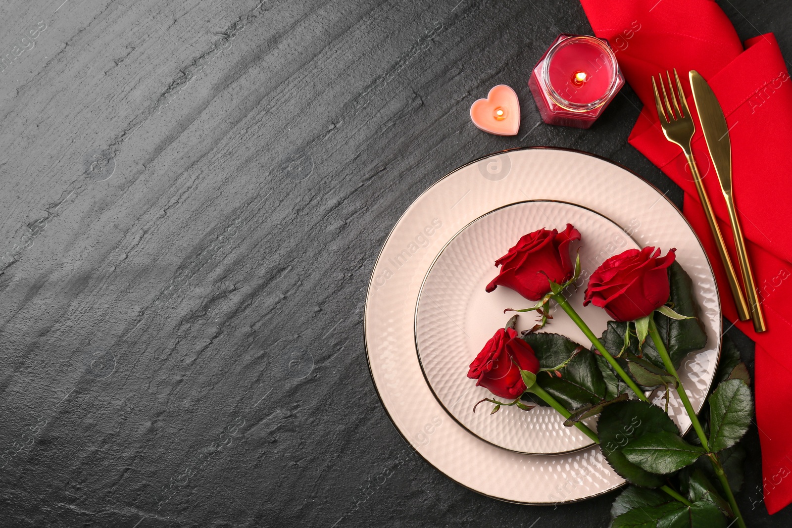 Photo of Place setting with candles and roses for romantic dinner on grey textured table, flat lay. Space for text