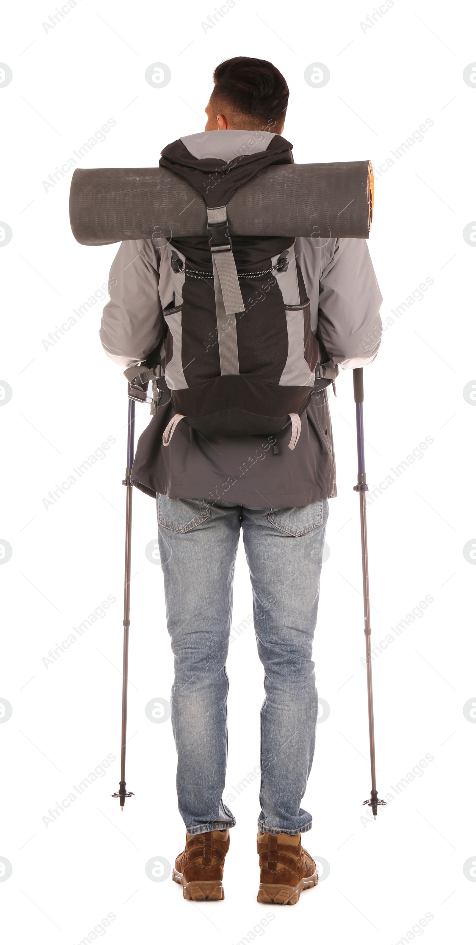 Photo of Male hiker with backpack and trekking poles on white background, back view