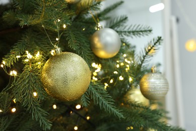Beautiful decorated Christmas tree with baubles and festive lights, closeup