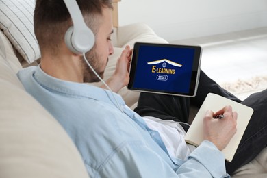 Image of Young man with headphones using modern tablet for studying at home, closeup. E-learning