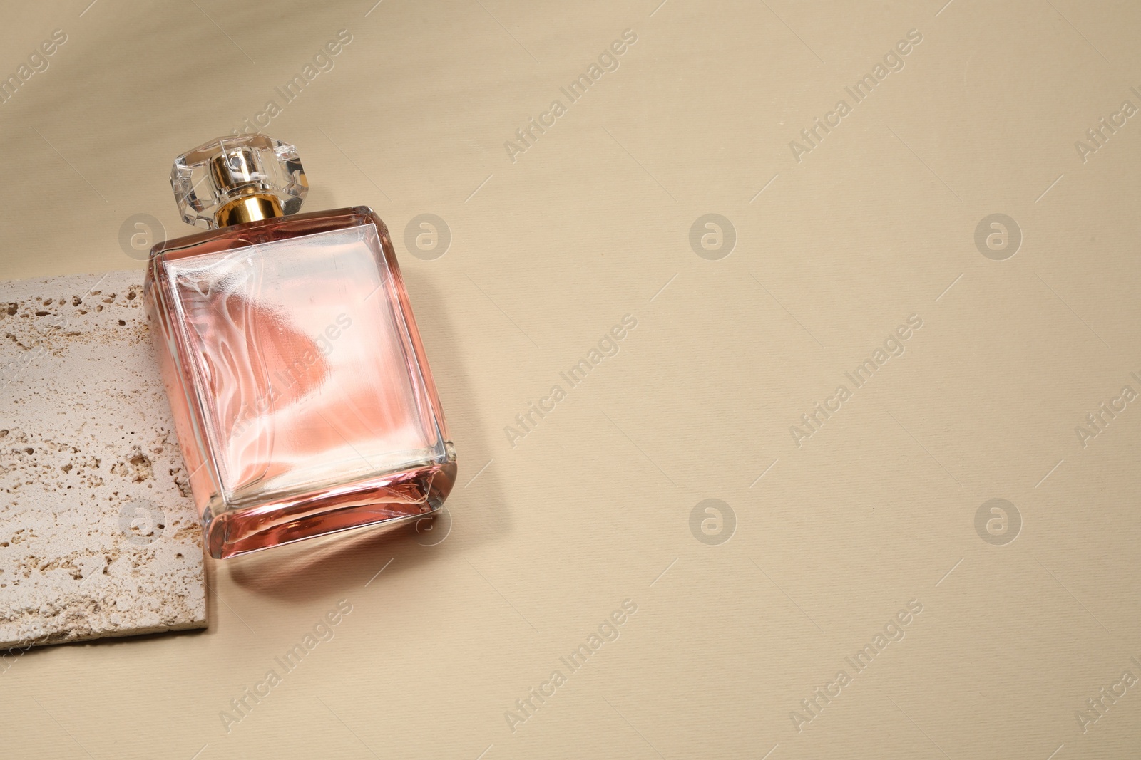 Photo of Luxury women's perfume in bottle on beige background, above view. Space for text