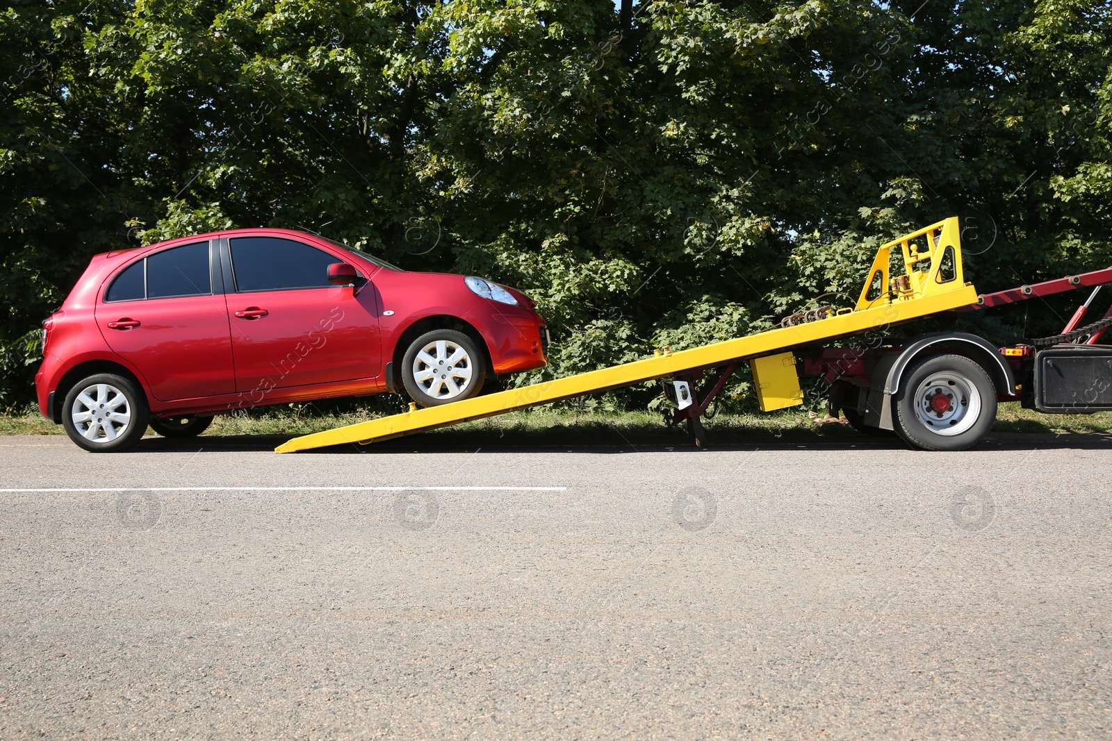 Photo of Broken car and tow truck on country road