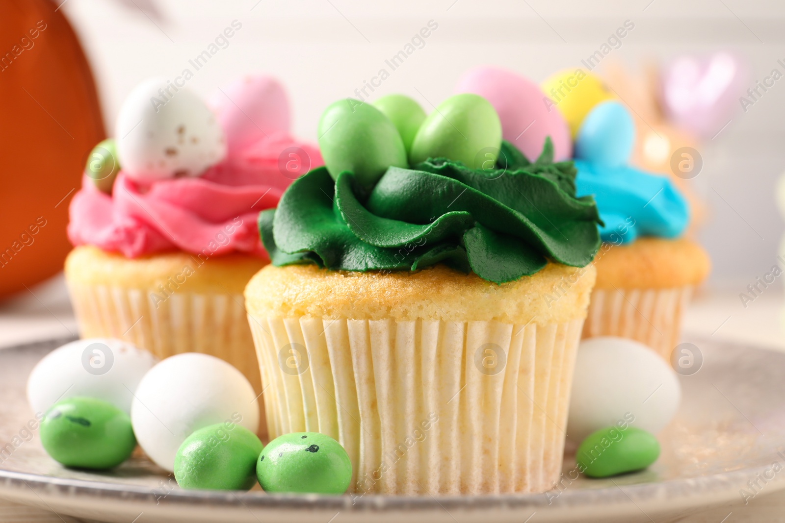 Photo of Tasty cupcakes with Easter decor on table, closeup