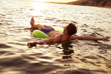 Young man with inflatable ring in sea