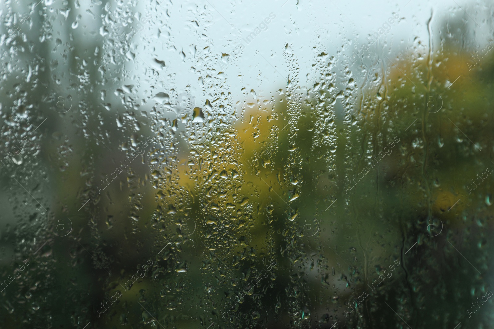 Photo of Rain drops on window glass as background, closeup