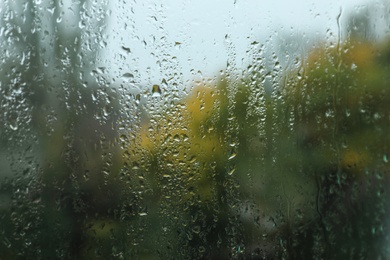 Photo of Rain drops on window glass as background, closeup