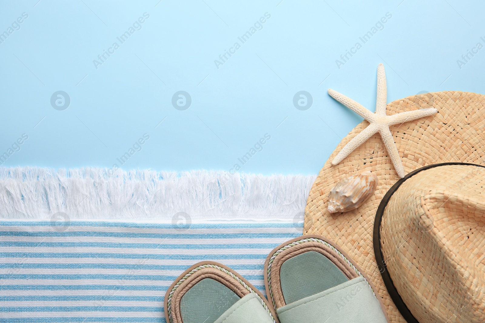 Photo of Flat lay composition with beach accessories on light blue background, space for text