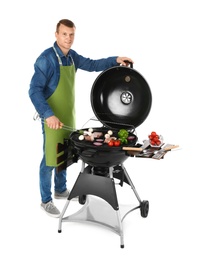 Man in apron cooking on barbecue grill, white background