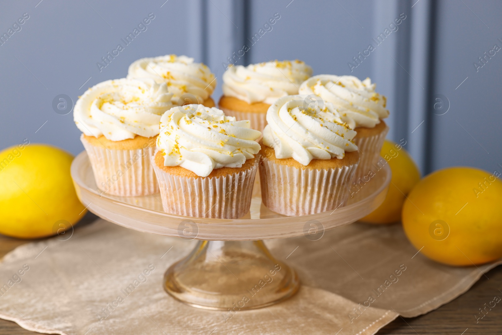 Photo of Delicious lemon cupcakes with white cream on table, closeup