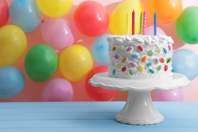 Photo of Delicious cake with cream and candles on light blue table. Space for text